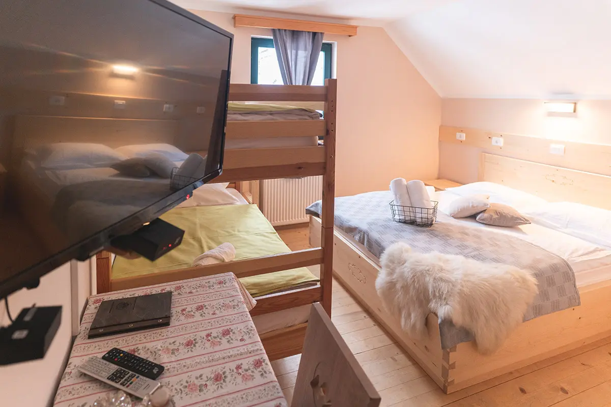 {"sl":"Udobna hotelska soba z zakonsko posteljo, pogradom, televizorjem in lesenim pohi\u0161tvom.","en":""}